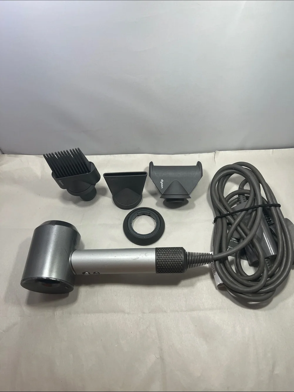 Dyson Hair Dryer with Multiple Dark Gray and Silver Styling Attachments